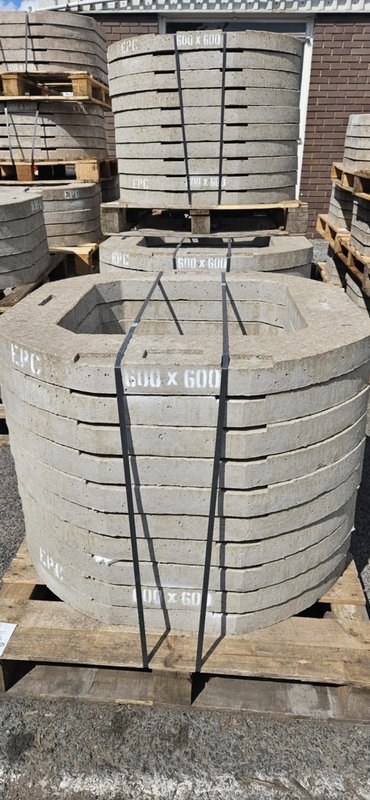 Banded stacks of 600x600 concrete seating rings on timber pallets