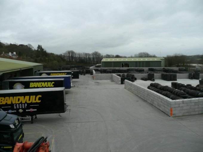 Duo block bays holding stock in a yard with trailers parked alongside