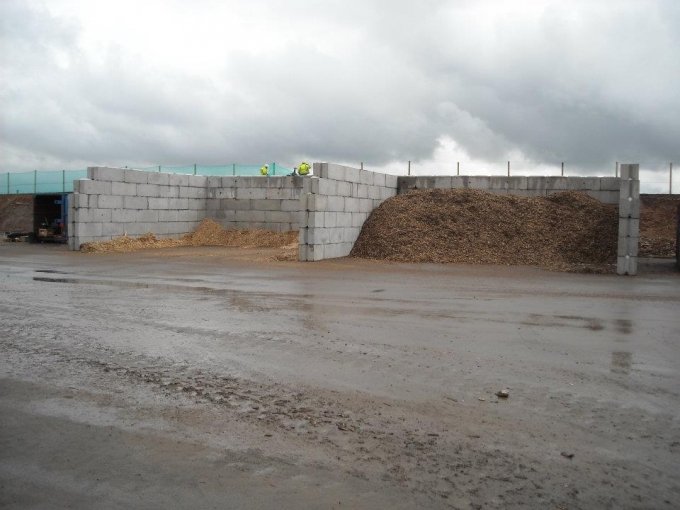 Legato interlocking block bays holding a large woodchip pile in a wet yard