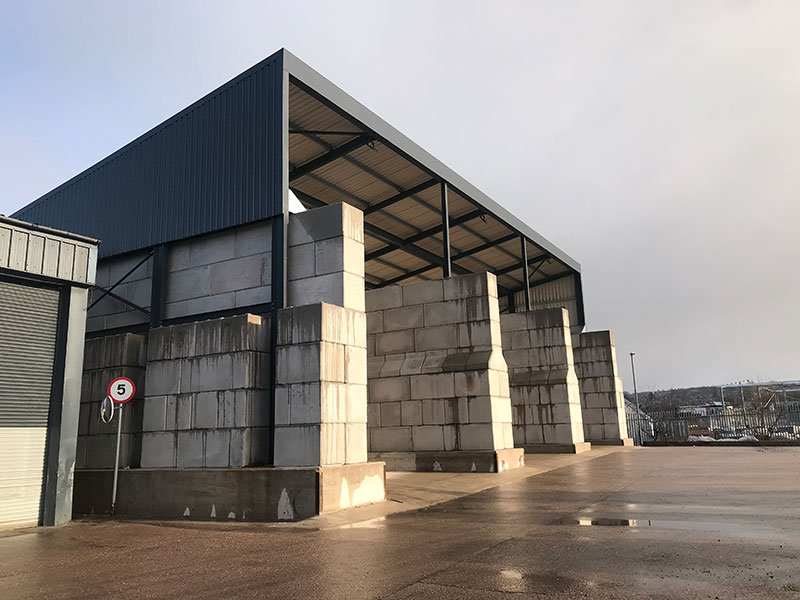 Legato interlocking blocks forming the walls of a large open-fronted storage building