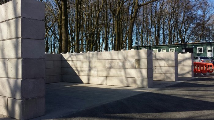 Duo interlocking block walls forming an open storage bay in a yard