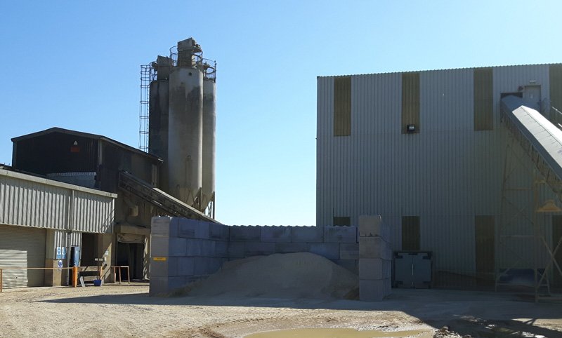 Interlocking block storage bay beside a silo at an aggregates plant