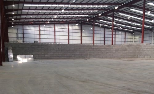 Long Duo block wall running the length of an empty warehouse