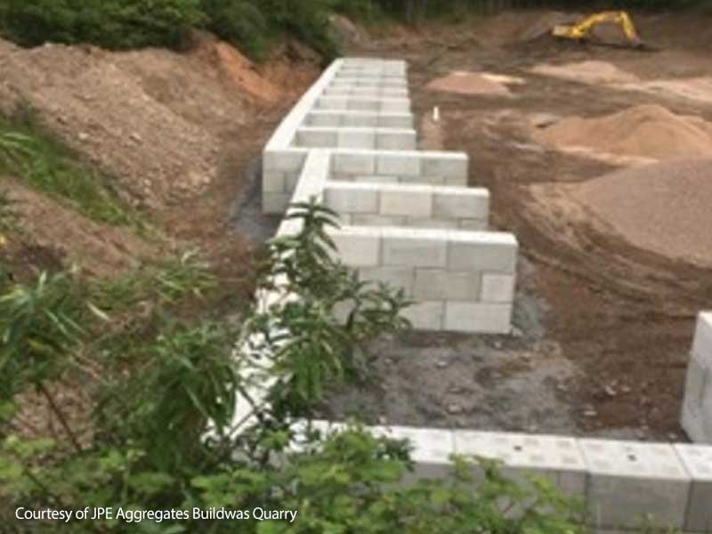Interlocking block bay walls under construction on a quarry stockpile area