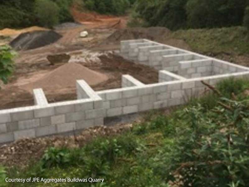 Concrete block storage bays filled with stockpiles of quarried aggregate