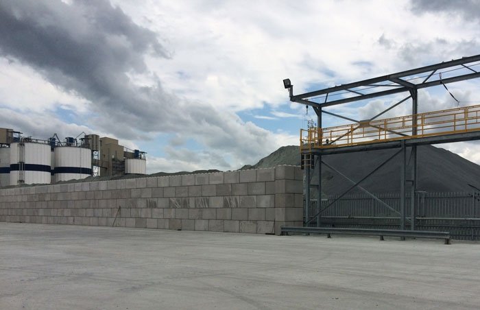 Legato storage bay wall in front of an aggregate stockpile and conveyor gantry
