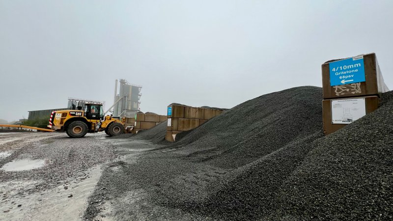 Loading shovel working between aggregate stockpiles in graded block storage bays
