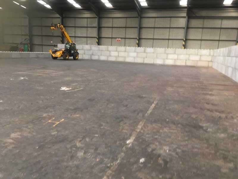 Telehandler building a Legato block wall around the inside of a warehouse