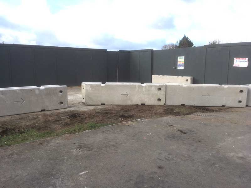 Linked TVCB barriers standing in a line against dark site hoarding