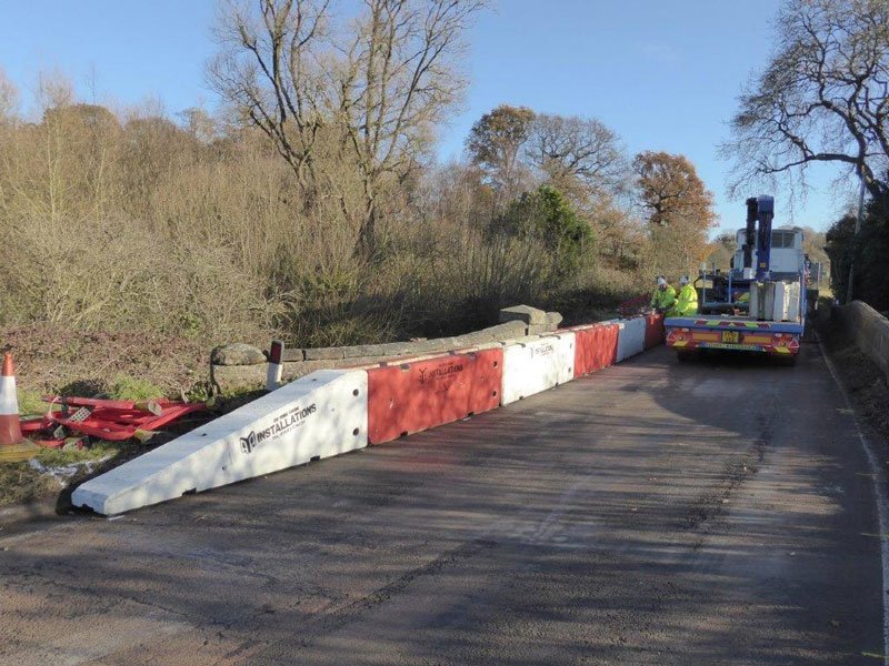 Temporary vertical concrete barriers closing off a lane during bridge repair works