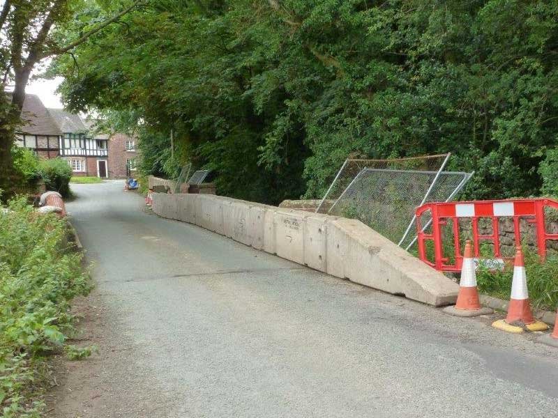 Temporary vertical concrete barriers protecting a road repair along a country lane