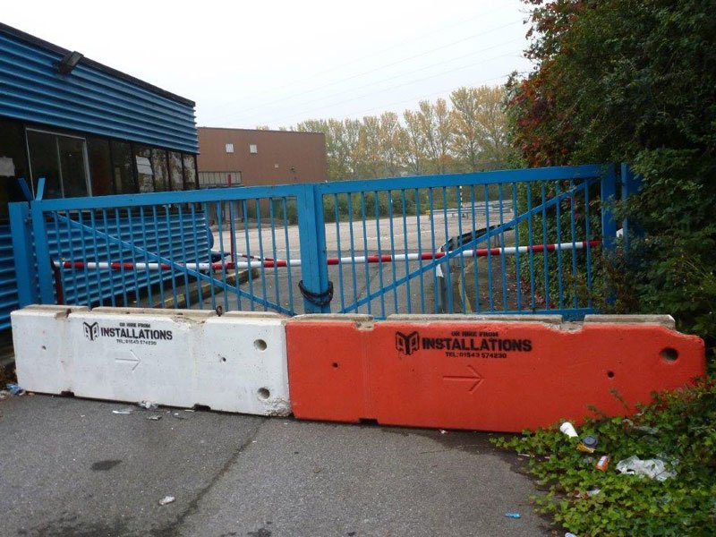 White and orange TVCB barriers blocking a gated business park entrance