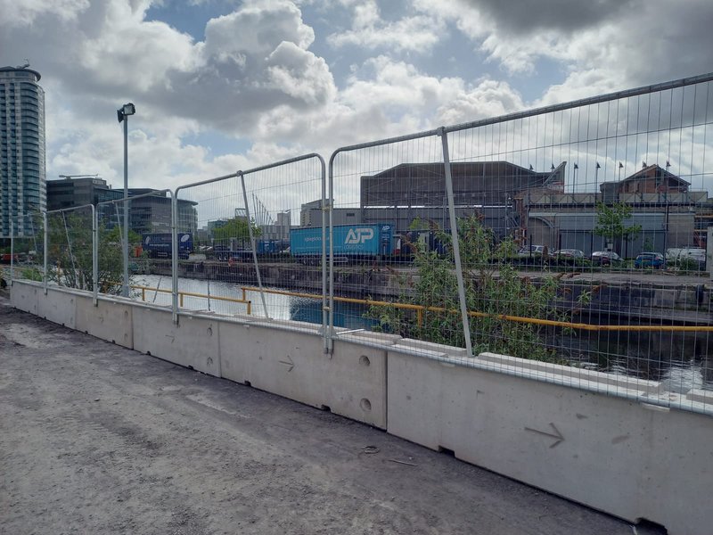 TVCB temporary vertical concrete barriers topped with mesh fencing at an industrial site