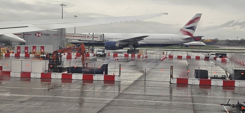 Red and white TVCB barriers screening works on an airport apron