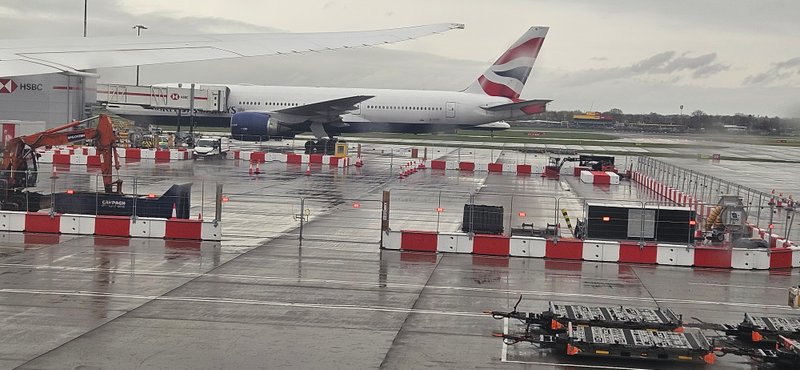 Barriers marking out works on an airport apron with a parked airliner behind