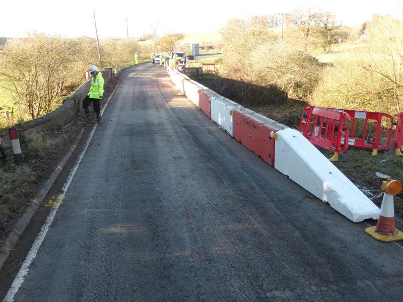Temporary vertical concrete barriers forming a protected walkway along a country road