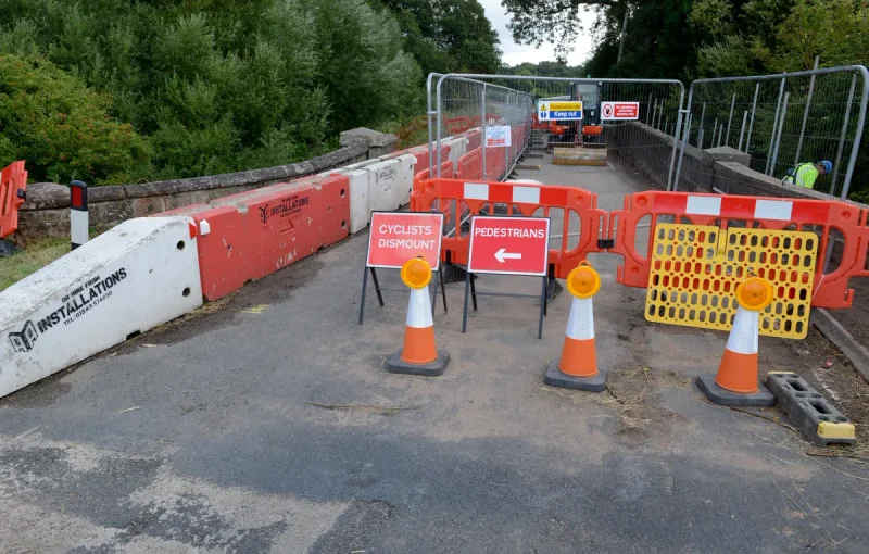 Concrete barrier, cones and diversion signs closing a road for emergency works