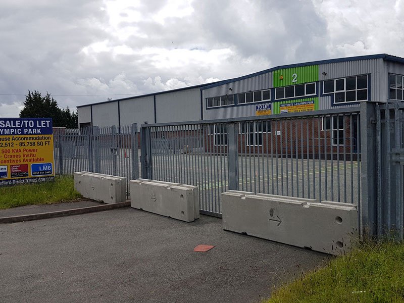 Concrete barriers closing the entrance to a gated industrial unit