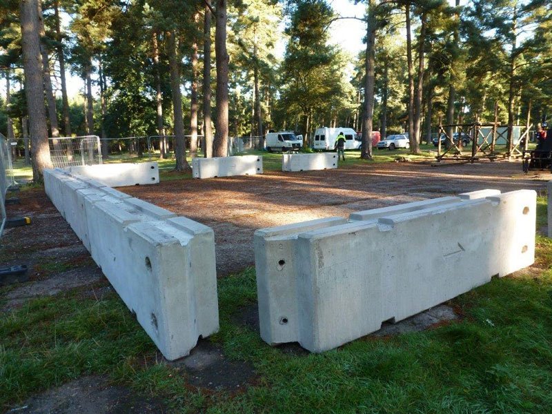 Concrete barriers laid out on grass to enclose an area in woodland