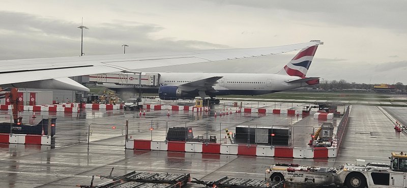 Red and white TVCB barriers on an airport apron beside a parked airliner
