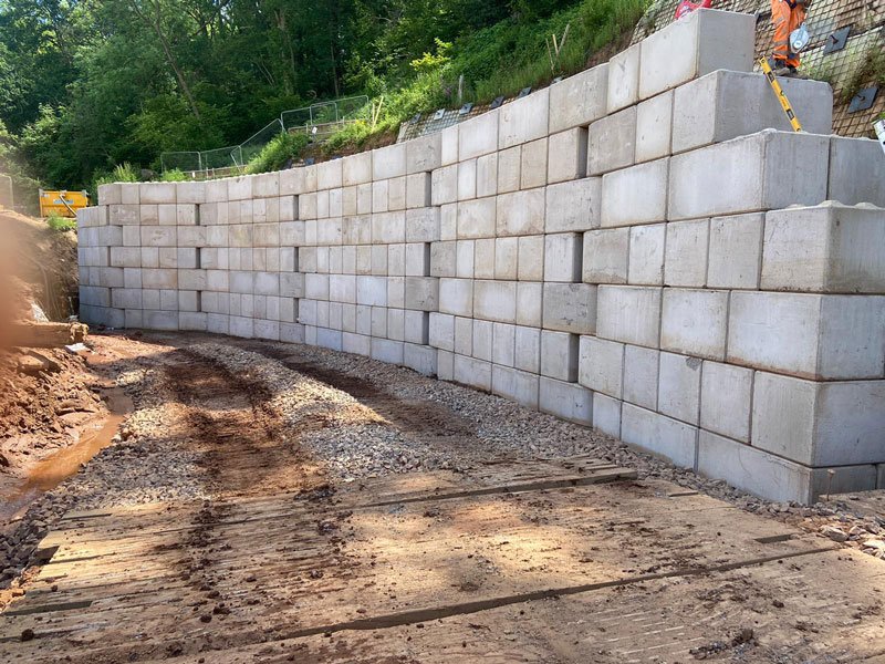 Curved Legato block wall retaining a wooded bank at a fish pass