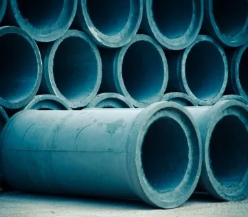 Stacked large-diameter precast concrete pipes seen end-on in a storage yard