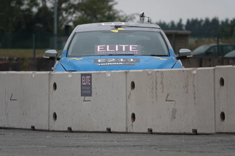 Branded car parked behind a line of temporary vertical concrete barriers