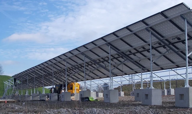 Ground-mounted solar panel array carried on concrete ballast blocks