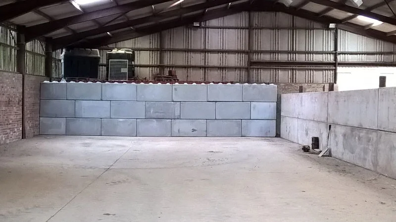 Duo blocks stacked into a division wall inside an empty farm storage building