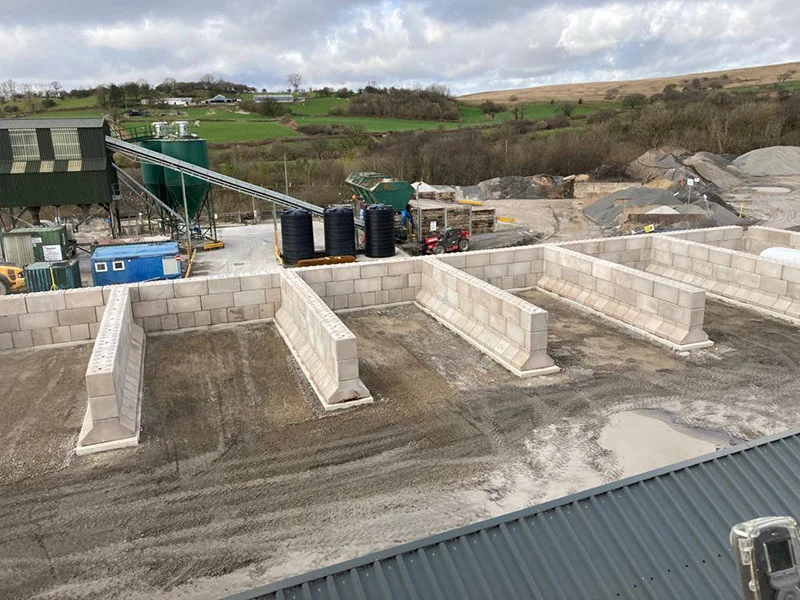 Storage bays formed from interlocking concrete blocks at a quarry processing site