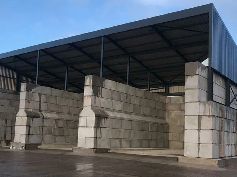 Legato interlocking block bay walls built beneath a steel-framed open-sided canopy