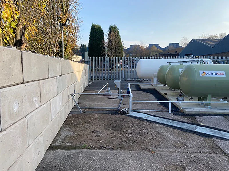 Interlocking block blast walling around gas tanks and pipework in a fenced compound