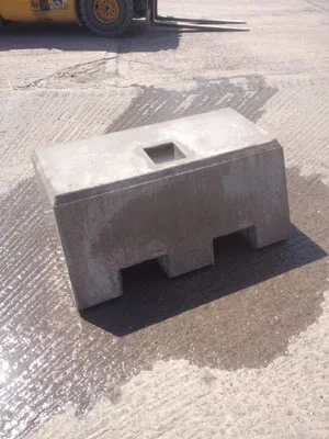 Kentledge ballast block with a central lifting pocket and forklift slots on a concrete yard