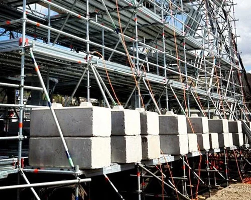 Duo blocks used as kentledge ballast along a scaffold run at an industrial plant