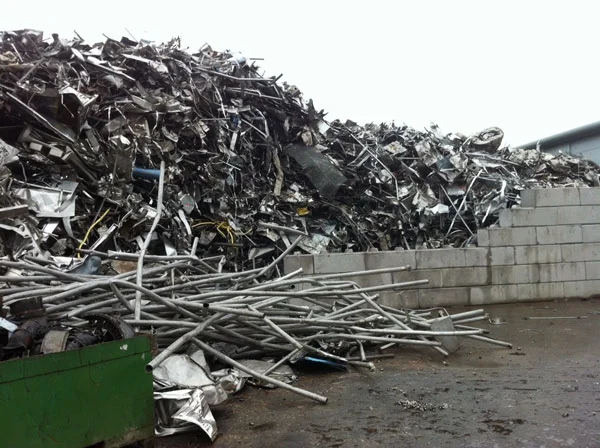 Duo blocks forming a bay wall holding back a large pile of scrap metal