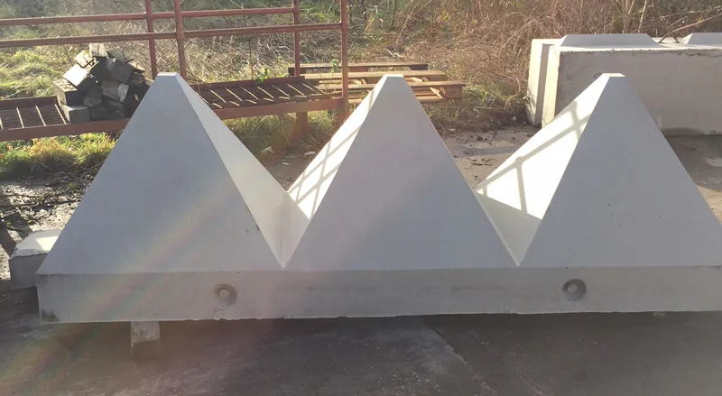 Row of pyramid tank trap barriers cast into a single concrete unit