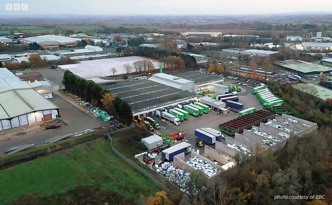 Aerial view of an industrial estate with warehouses, yards and stacked materials