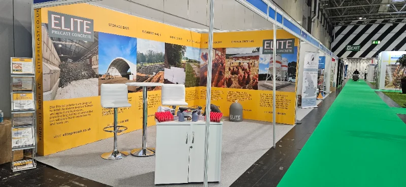 Branded exhibition stand with yellow display boards at an indoor trade show