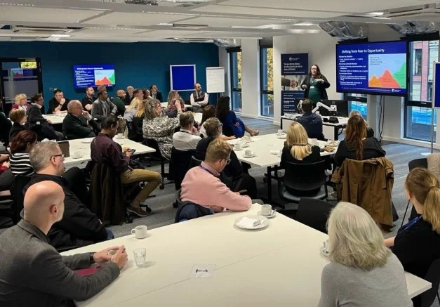 Delegates seated at tables watching a presentation at a business networking event